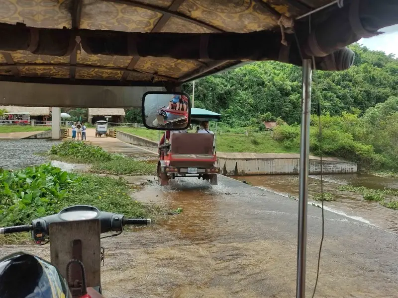A tuk-tuk crossing the dam at Secret Lake near Kampot