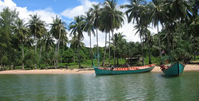 Wooden boats moored off the palm-fringed beach of Rabbit Island (Koh Tonsay), off Kep